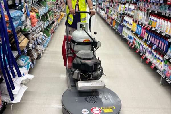 Kowhai Cleaning staff performing industrial-grade floor polishing in busy supermarket aisle