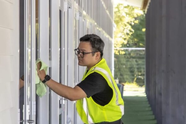 Professional school cleaning by Kowhai Cleaning technician polishing windows in educational facility