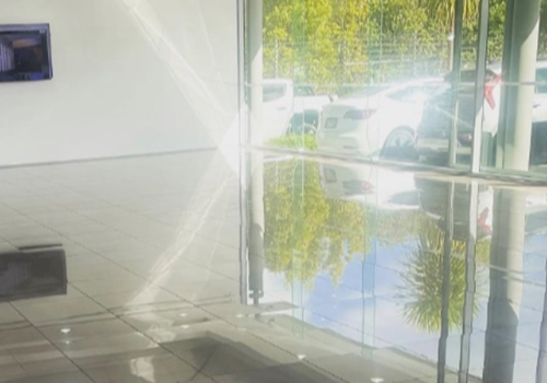 High gloss showroom floor tiles in Botany vehicle detailing bay reflecting cars after professional silicone removal.